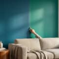 A hand points to a wall split between 'bleu canard' and 'vert canard' teal, in a stylish living room with a sofa and natural light.