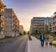 Late afternoon in Sarcelles showing contrasting old and modern residential buildings with a family walking on a clean sidewalk.