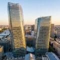 Vue aérienne panoramique des Tours Duo en verre asymétriques dominant les bords de Seine à Paris au coucher du soleil.